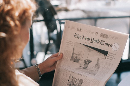 Businesswoman reading NY Times newspaper