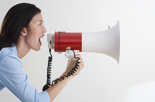 A woman shouting with a megaphone, promoting her brand