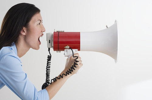 A woman shouting with a megaphone, promoting her brand