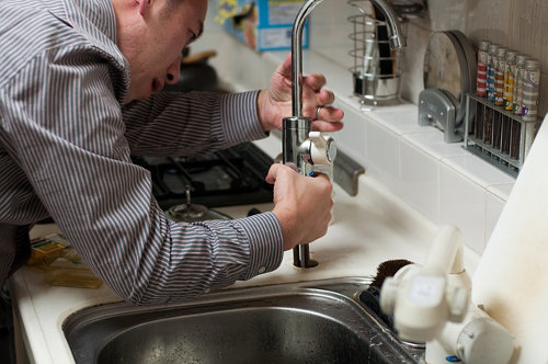 Commercial plumber fixing a faucet