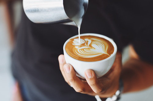 Coffee shop owner pouring coffee