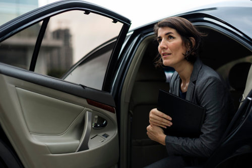 Businesswoman gets out of a business car