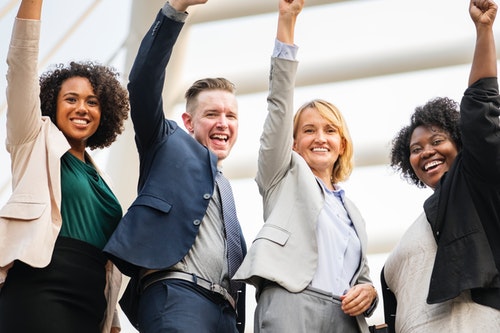 Group of entrepreneurs holding their hands up as winners