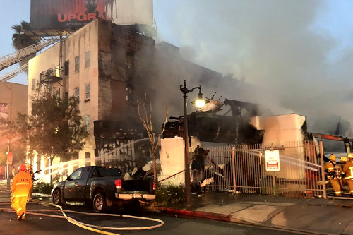 Firemen extinguishing business premise on fire