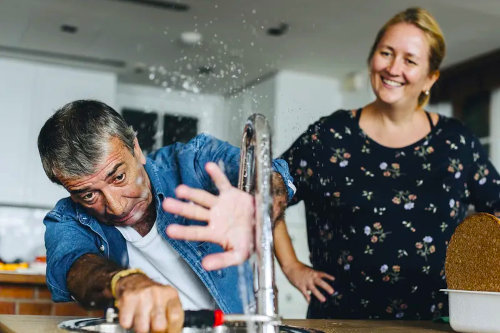 Plumber fixing leaked faucet